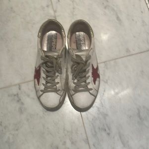 Golden goose sneakers with red sequin star.